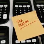 Kalkulatory i karteczka Tax Season jako symbol wyboru formy opodatkowania
