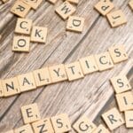 Kafle scrabble układające się w słowo Analytics na drewnianym blacie