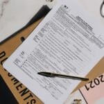 Formularz podatkowy z długopisem i okularami na marmurowym blacie