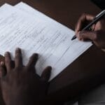 Mężczyzna podpisuje oficjalne dokumenty przy biurku