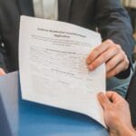 Przedsiębiorca przekazuje doradcy wniosek kredytowy w biurze banku