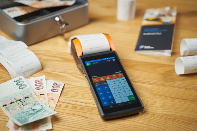 Terminal płatniczy, gotówka i paragony na drewnianym biurku